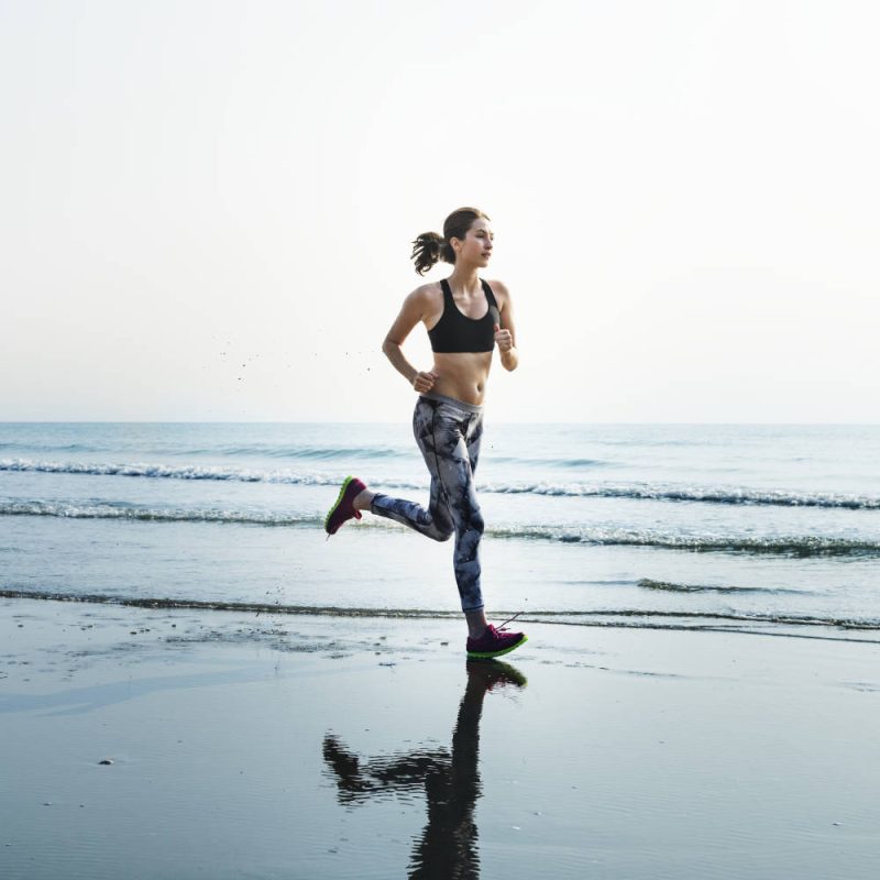 Sporty woman running at the beach